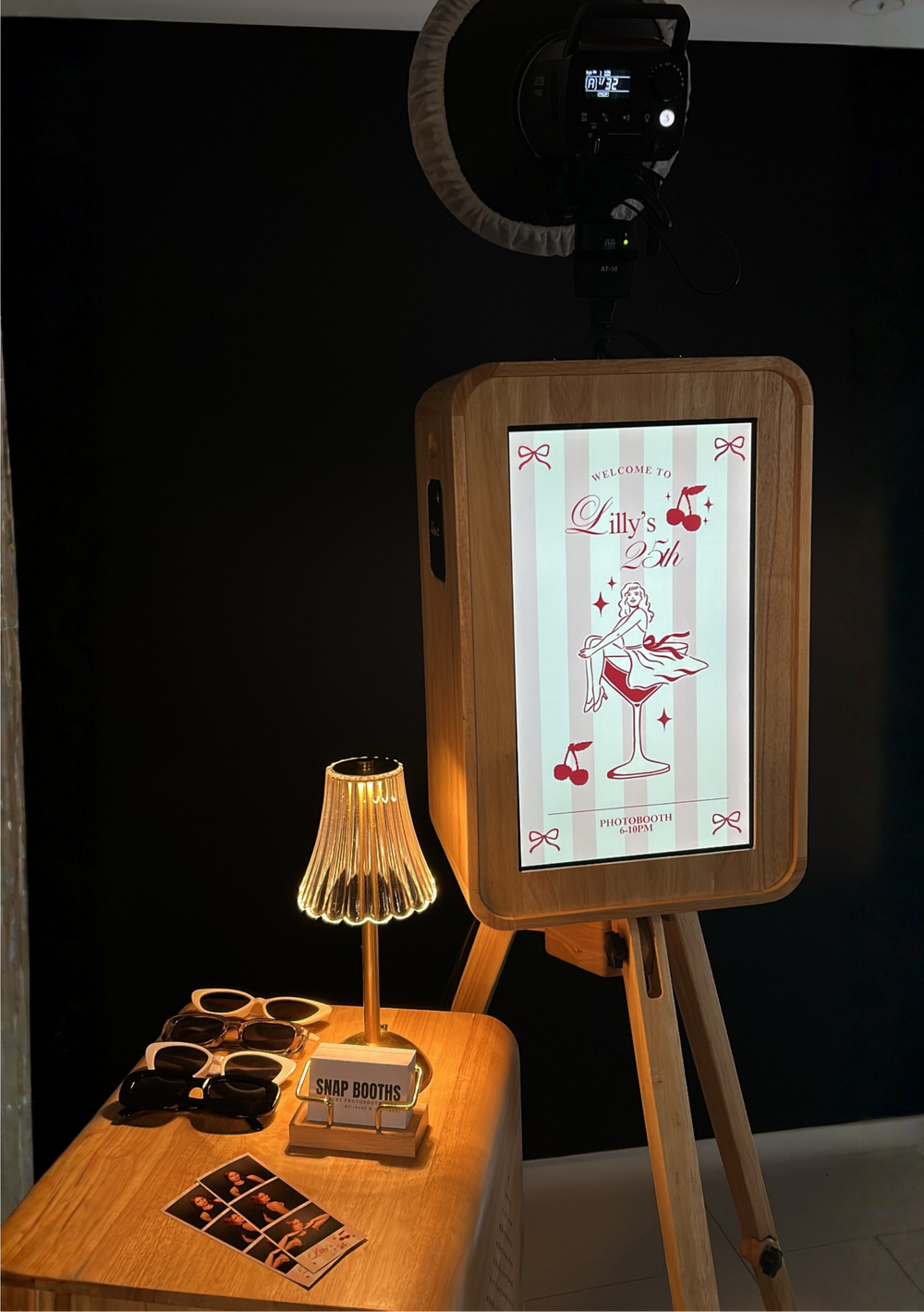 Wooden photo booth with screen and props on a white background