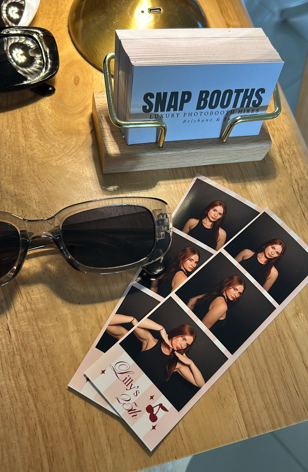 Snap Booths sign with instant photos on a wooden surface