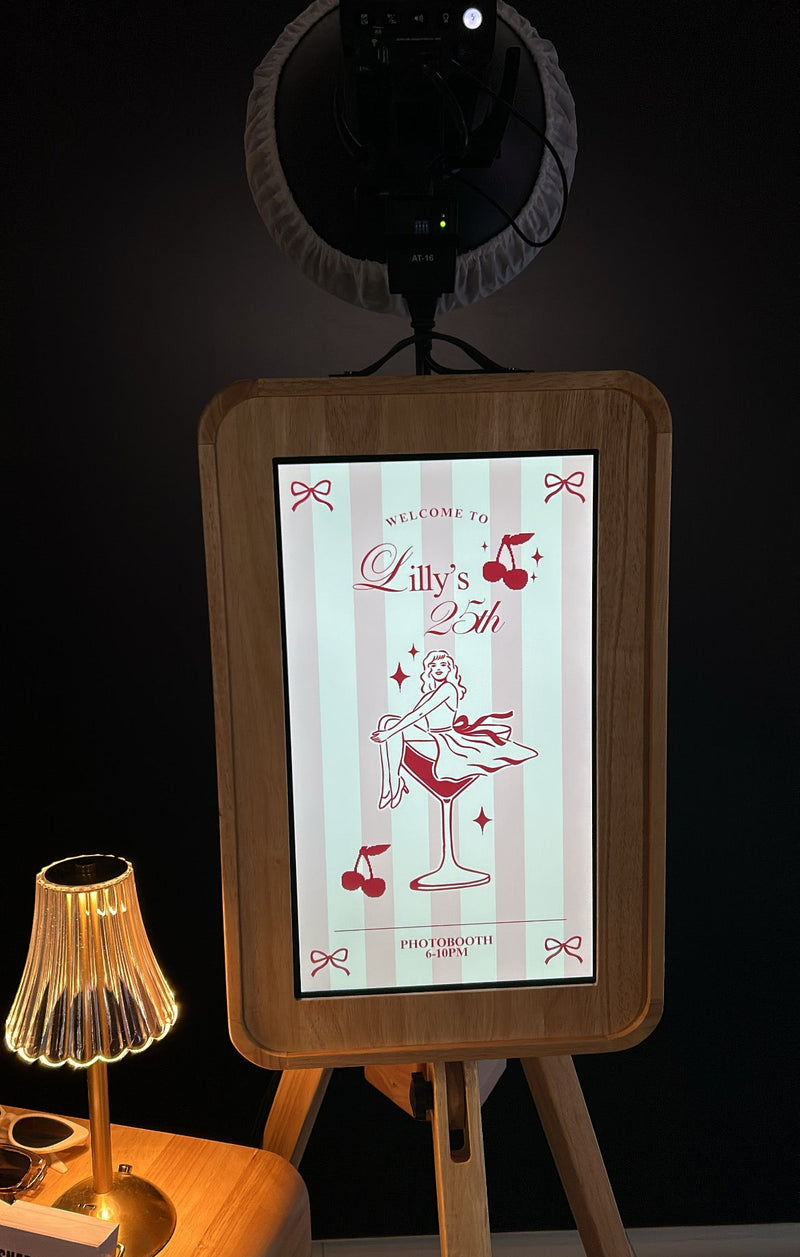 Digital display board with a birthday-themed design on an easel against a dark background.