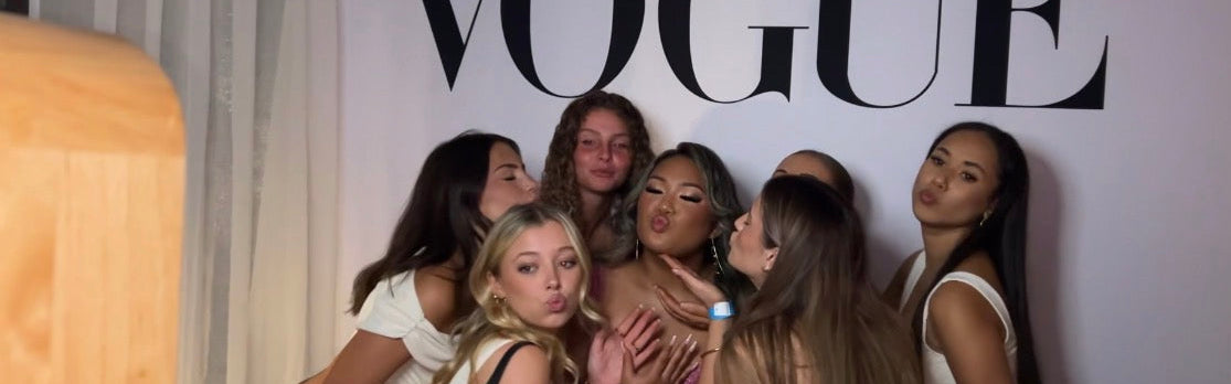 Group of women posing in front of a Vogue sign